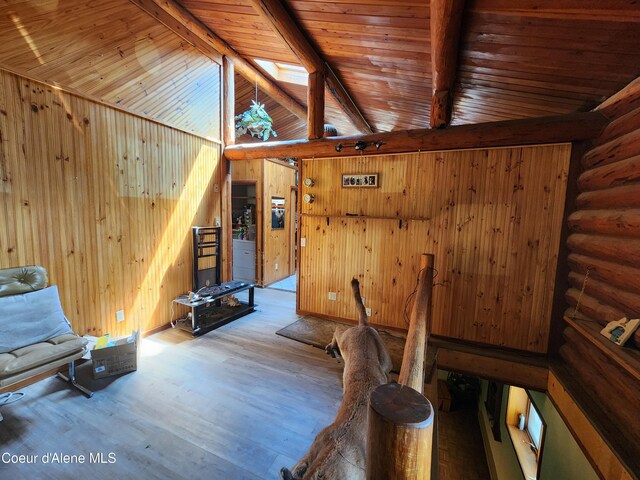 unfurnished room with rustic walls, wooden ceiling, vaulted ceiling with beams, wood-type flooring, and wooden walls