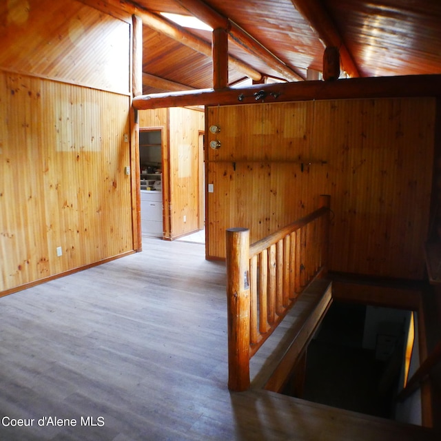 interior space with vaulted ceiling with beams, wood walls, wood ceiling, and light wood-type flooring