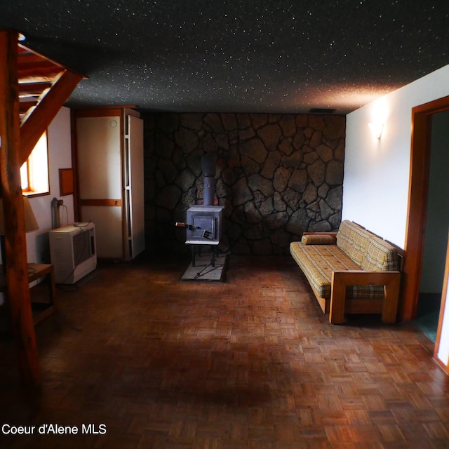 interior space with a wood stove and parquet flooring