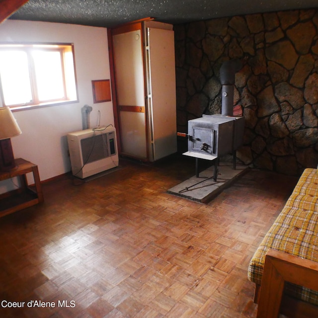 living room with a wood stove, parquet flooring, and heating unit