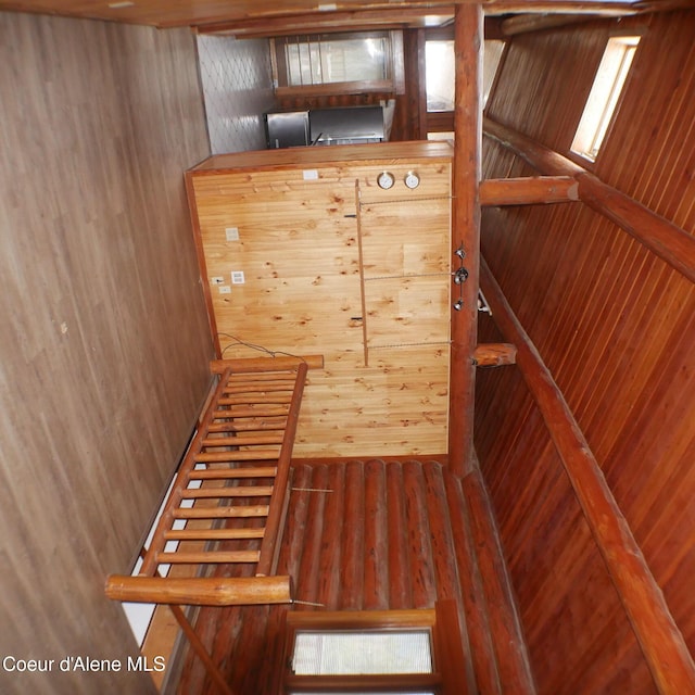 stairway with hardwood / wood-style flooring and wooden walls