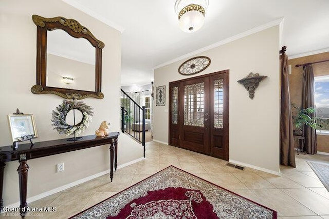 tiled entrance foyer with visible vents, plenty of natural light, ornamental molding, and stairs