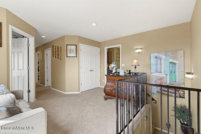 hall featuring an upstairs landing, recessed lighting, carpet flooring, and baseboards