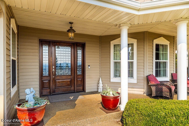 view of exterior entry featuring covered porch