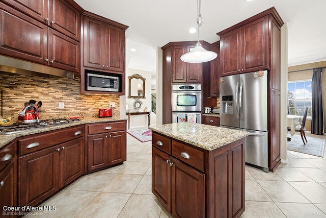 kitchen with tasteful backsplash, stainless steel appliances, pendant lighting, and light tile patterned floors