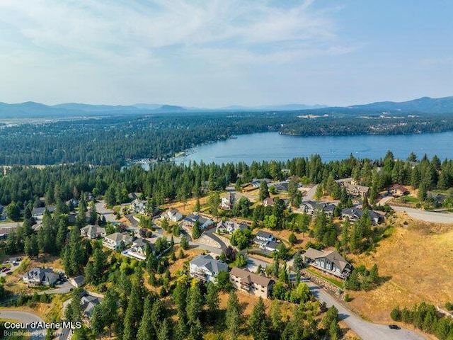 birds eye view of property featuring a wooded view, a residential view, and a water and mountain view