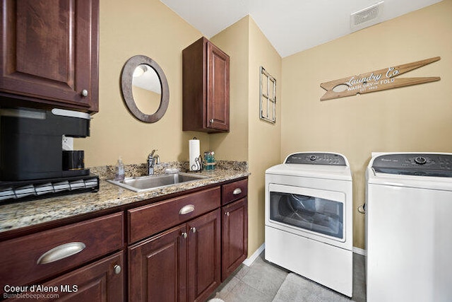 laundry area with cabinets, light tile patterned floors, sink, and washer and dryer