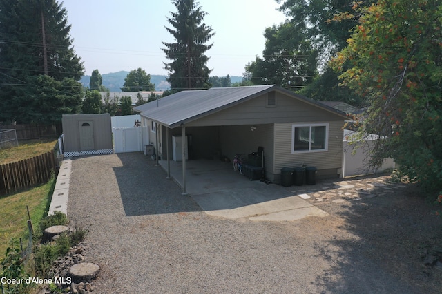 exterior space featuring a carport, a gate, fence, and driveway