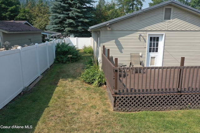 view of yard featuring a wooden deck and fence