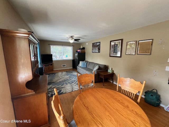 living area with visible vents, wood finished floors, baseboards, and ceiling fan