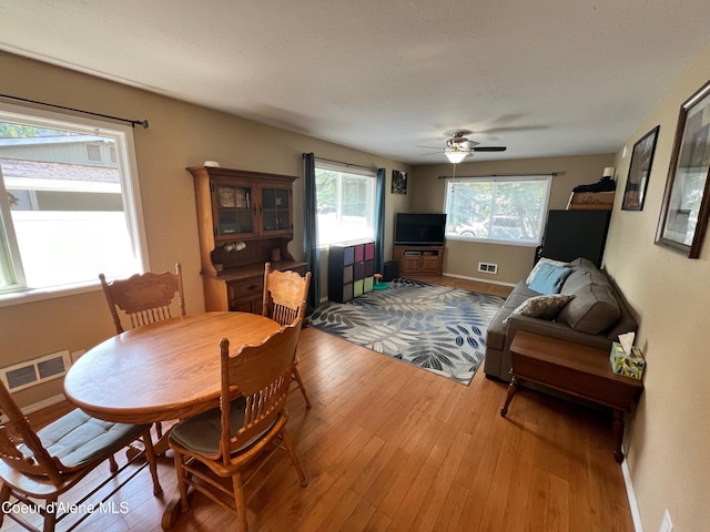 dining room featuring visible vents, ceiling fan, baseboards, and hardwood / wood-style floors