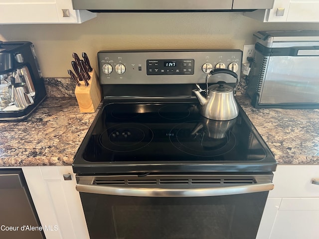 interior details featuring mail area, white cabinets, range with electric stovetop, and stainless steel microwave