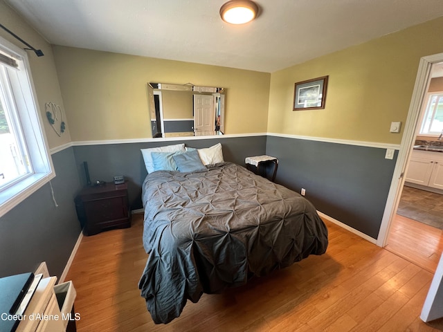 bedroom featuring hardwood / wood-style flooring and baseboards