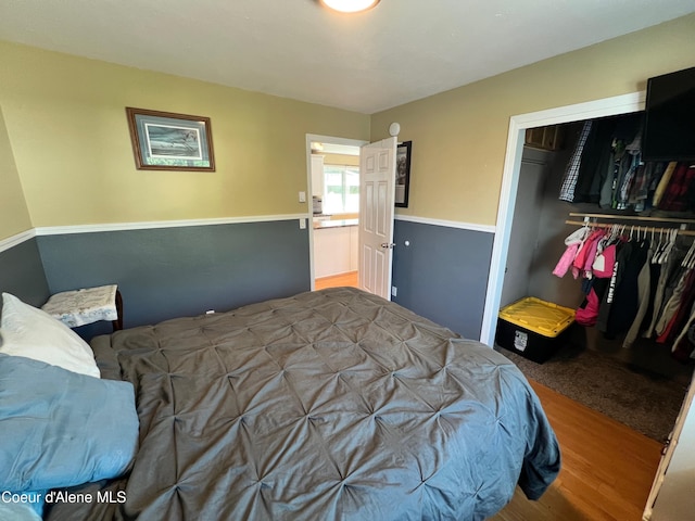 bedroom with wood finished floors and a closet