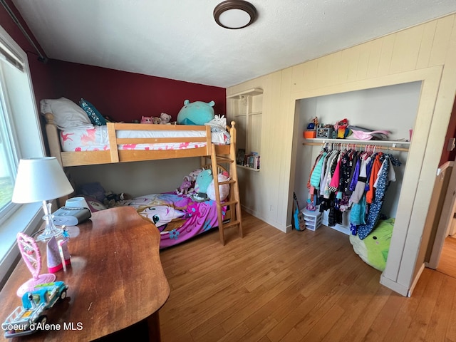 bedroom with a closet, multiple windows, and wood finished floors