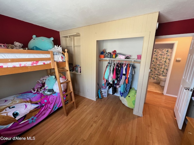 bedroom with wood finished floors, a closet, and a textured ceiling