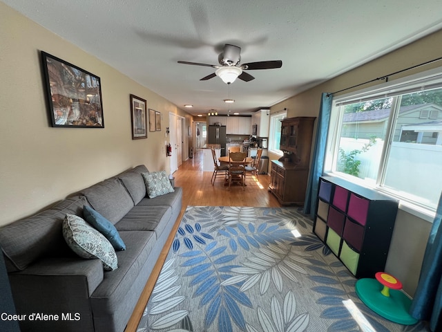 living room with wood finished floors and a ceiling fan