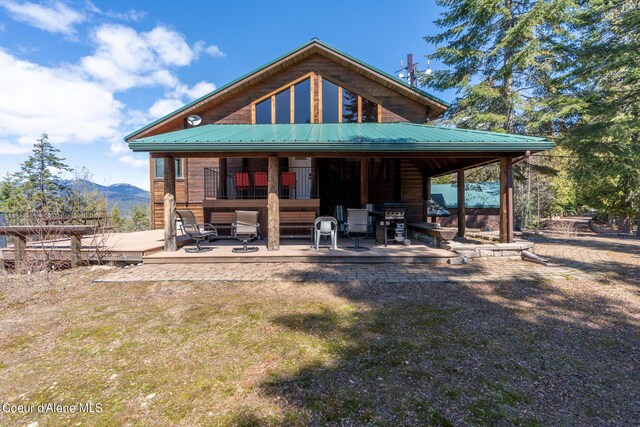 back of property featuring a mountain view and a patio