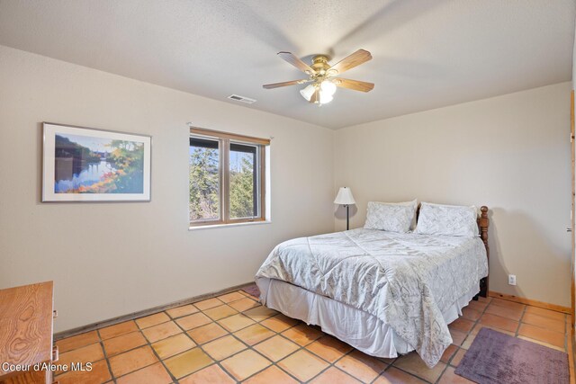 tiled bedroom featuring ceiling fan