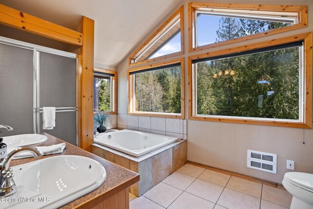 full bathroom featuring tile patterned flooring, lofted ceiling, shower with separate bathtub, toilet, and vanity