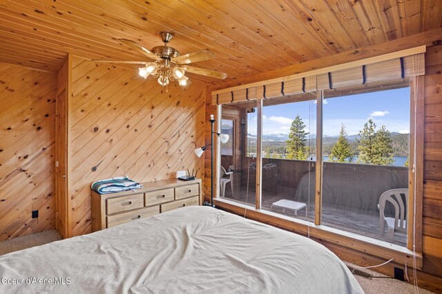 bedroom with access to outside, wood walls, ceiling fan, and wood ceiling