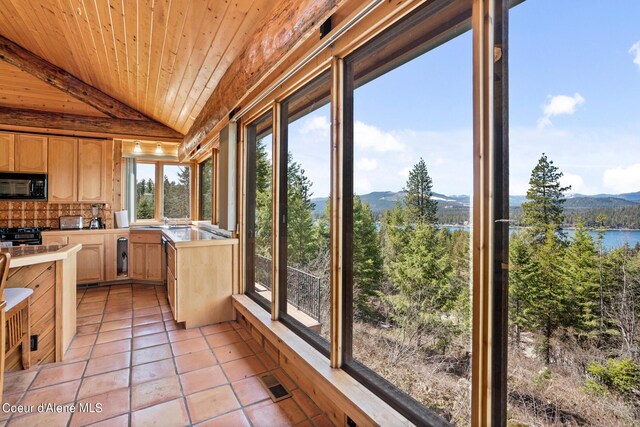 unfurnished sunroom featuring a water and mountain view, wood ceiling, and vaulted ceiling