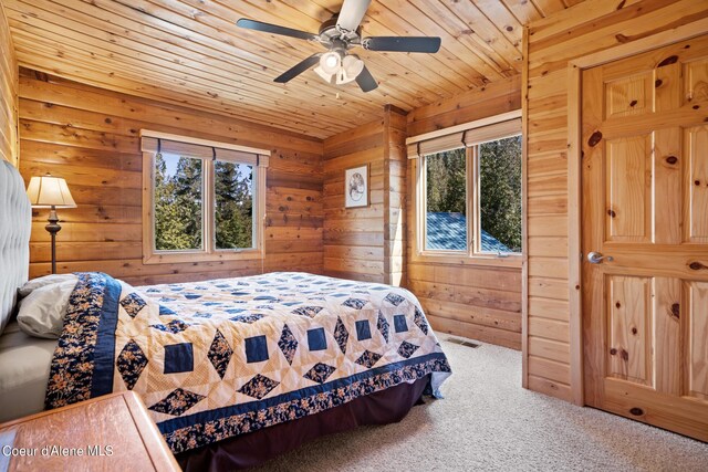 carpeted bedroom featuring ceiling fan, wooden ceiling, and wooden walls