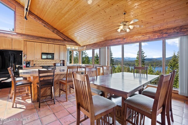 dining area featuring a water and mountain view, high vaulted ceiling, wood ceiling, and plenty of natural light