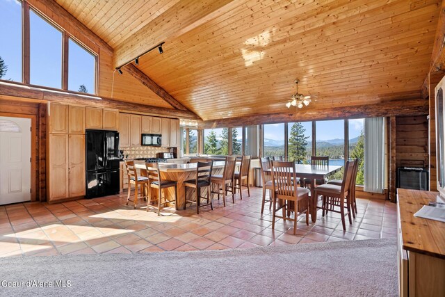 tiled dining space with a mountain view, ceiling fan, high vaulted ceiling, wooden ceiling, and beamed ceiling