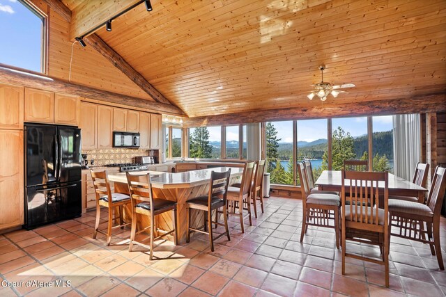 dining area with high vaulted ceiling, track lighting, a water and mountain view, beam ceiling, and wood ceiling