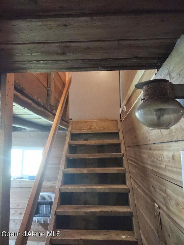 staircase featuring wood walls