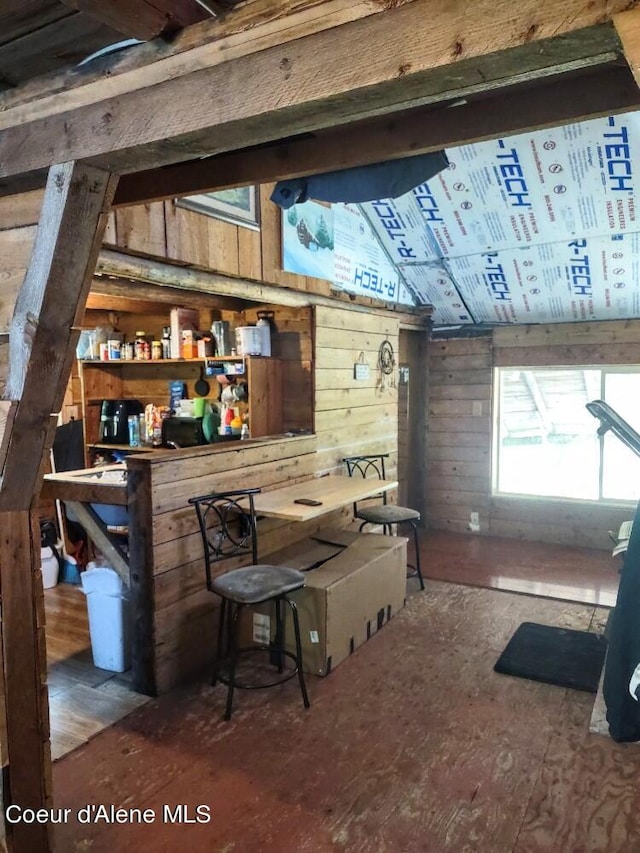 interior space with wood-type flooring, wood walls, and lofted ceiling