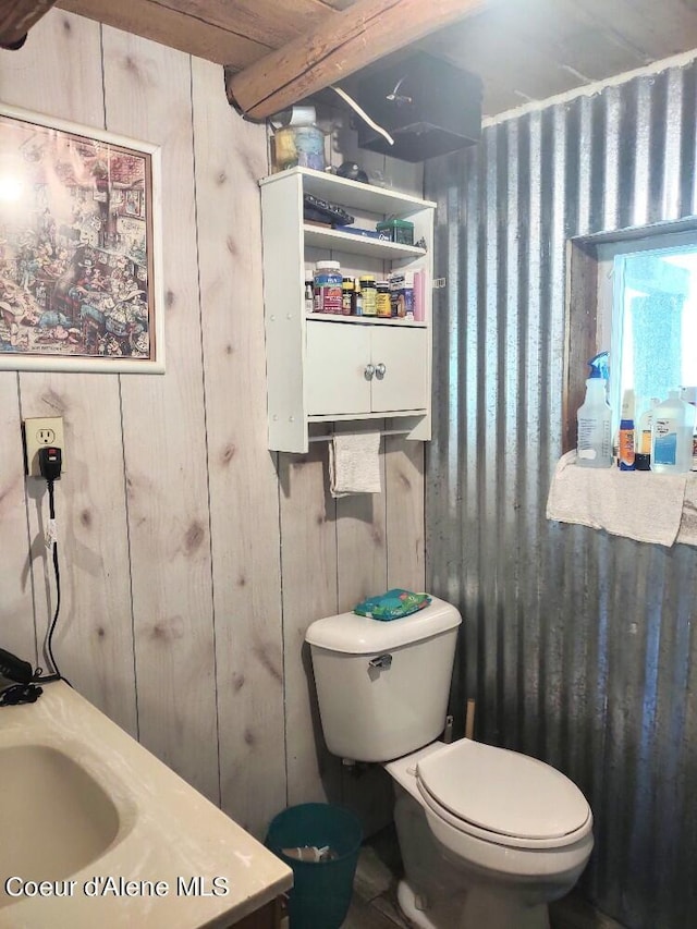 bathroom with wood walls and toilet