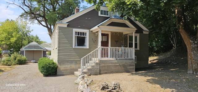 view of front of house featuring a storage shed and a porch