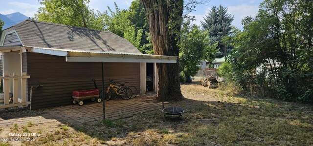 view of yard with a fire pit and an outdoor structure