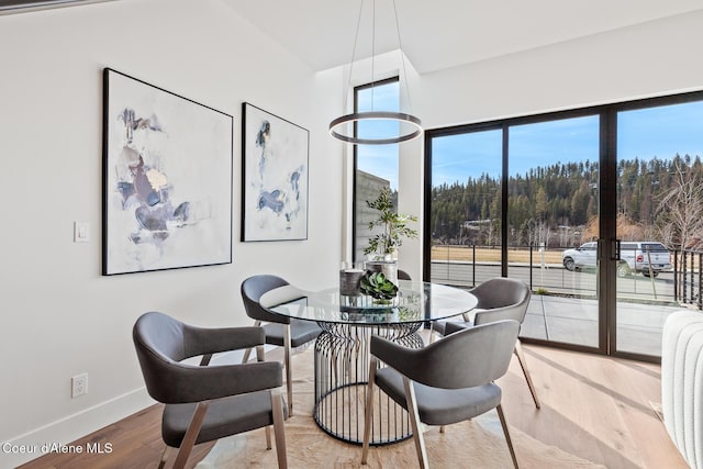 dining area with baseboards and wood finished floors