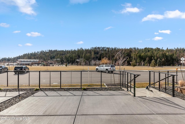 view of patio / terrace with fence, a view of trees, and area for grilling