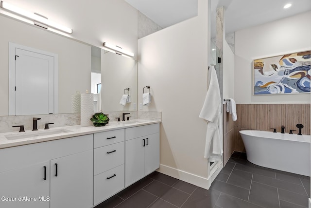 full bathroom featuring double vanity, a wainscoted wall, a sink, and tile patterned floors