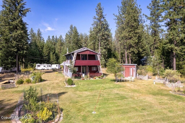 exterior space featuring an outdoor structure, a shed, and a forest view
