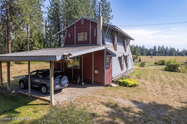 view of outdoor structure featuring a lawn and a carport