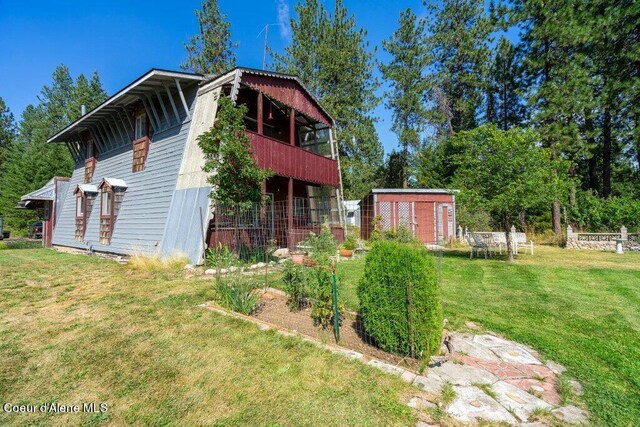 view of side of property with an outbuilding and a lawn