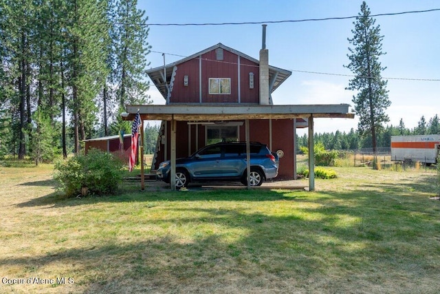 back of house with a lawn and a carport