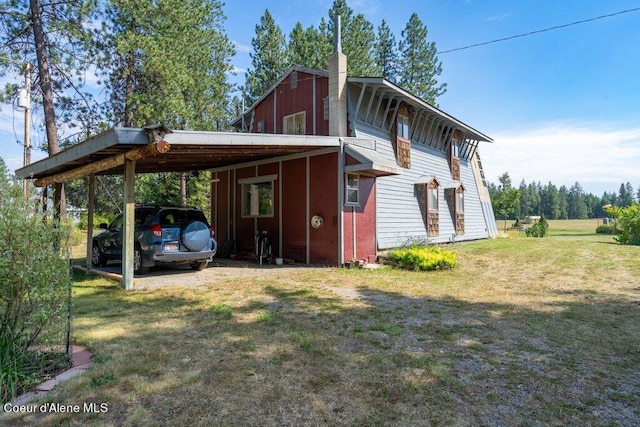 back of property with a yard and a carport