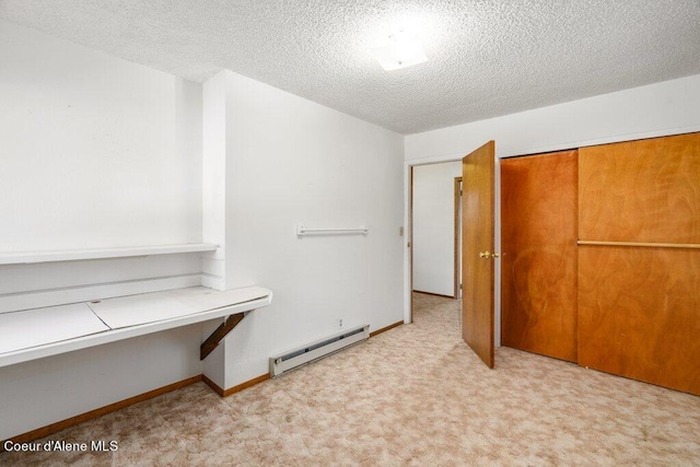 unfurnished bedroom featuring light carpet, a textured ceiling, a closet, and a baseboard radiator