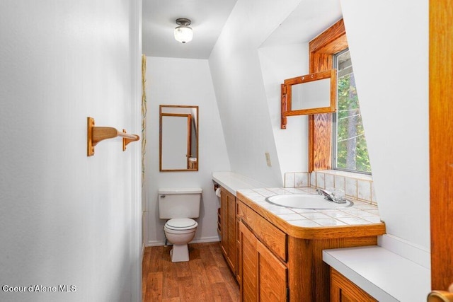 bathroom with toilet, wood finished floors, and vanity