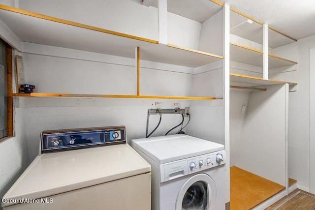 laundry area with washer and dryer, wood finished floors, and laundry area