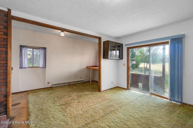 unfurnished living room featuring a textured ceiling, baseboard heating, and a wealth of natural light