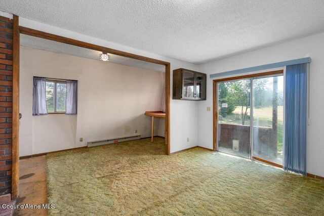 carpeted spare room with a baseboard radiator, plenty of natural light, baseboards, and a textured ceiling