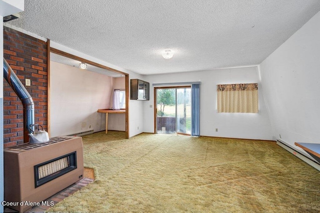 unfurnished living room with heating unit, a baseboard radiator, carpet, a wood stove, and a textured ceiling