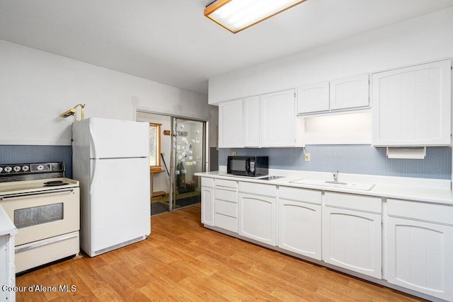 kitchen with sink, light hardwood / wood-style floors, white appliances, and white cabinetry